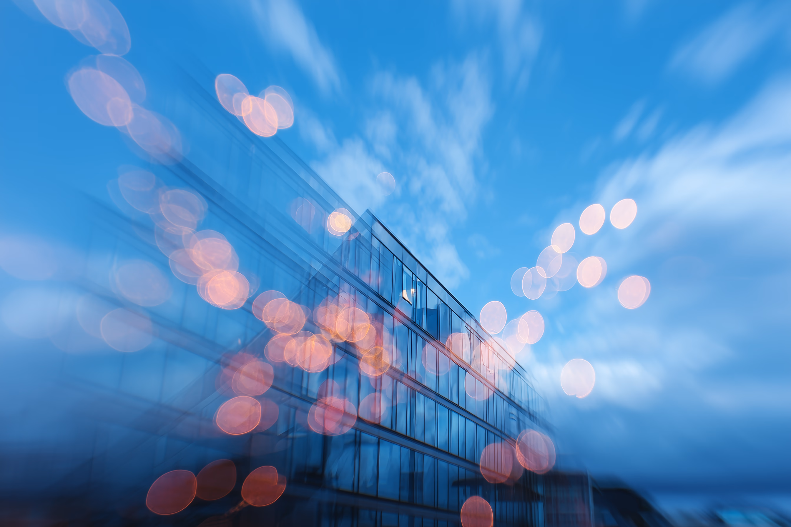 Modern glass architecture layered with warm city lights